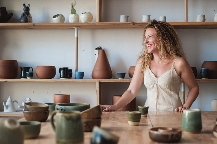 A portrait of a ceramic artist smiling in her studio