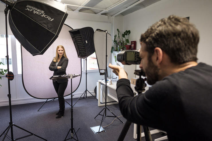 A behind the scenes photo of a portrait photographer working in an office