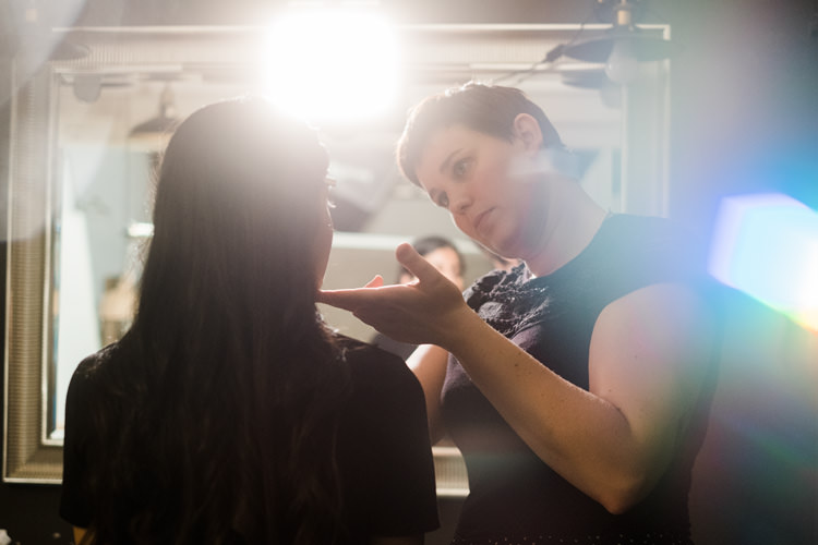 A professional makeup artist applying makeup to a young woman